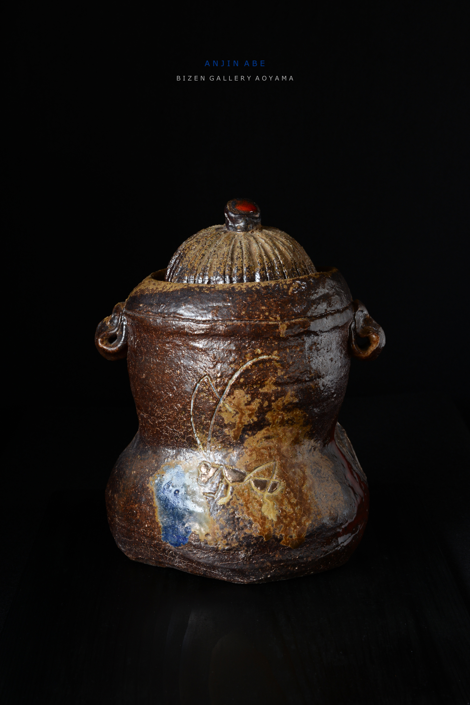 A ceramic jar with a textured lid and decorative painting, displayed against a black background.